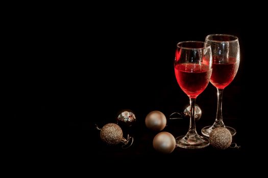 Celebration theme with  two red wine glass and Golden round ball on  black background