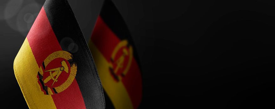 Small national flags of the GDR on a dark background.