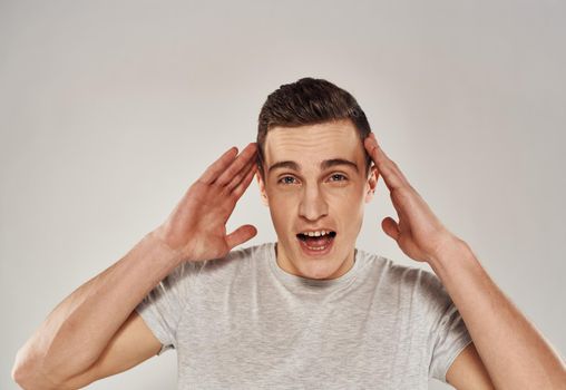 cheerful man gesturing with his hands in a white t-shirt light background cropped view. High quality photo