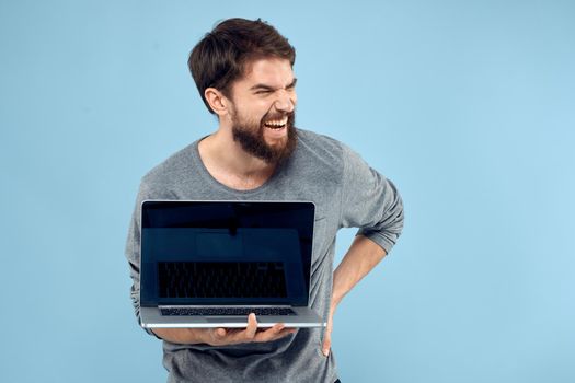 Man with laptop in hands technology communication professionals work blue background. High quality photo