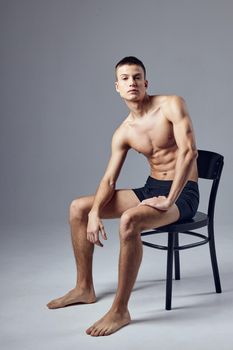 sporty man with pumped up muscular body sitting on chair isolated background fitness. High quality photo