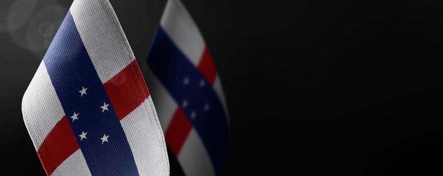 Small national flags of the Netherlands Antilles on a dark background.