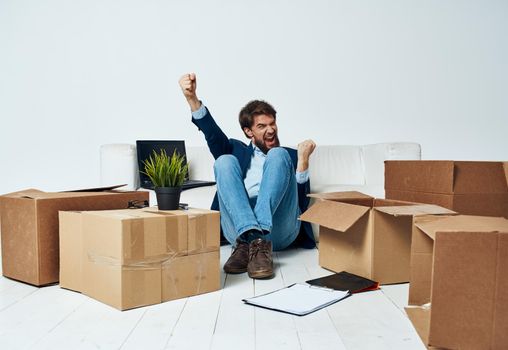Man sitting on the floor with boxes of stuff moving to office unpacking lifestyle. High quality photo