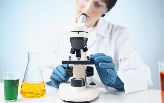 doctors in medical gloves look through a microscope on the table e laboratory chemical element vaccine. High quality photo