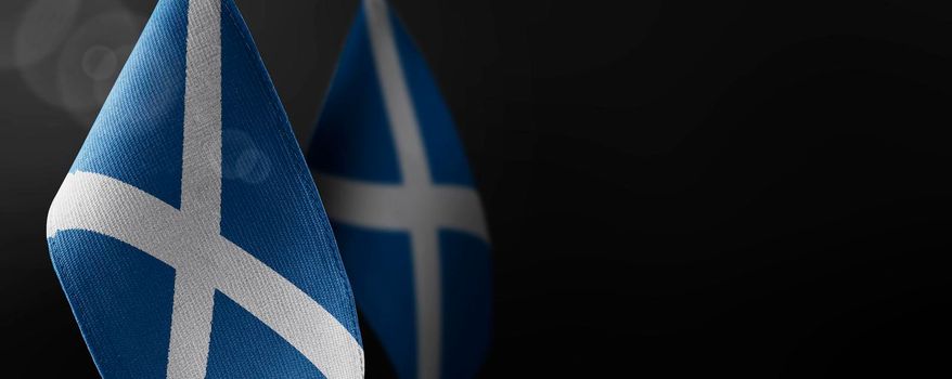 Small national flags of the Scotland on a dark background.