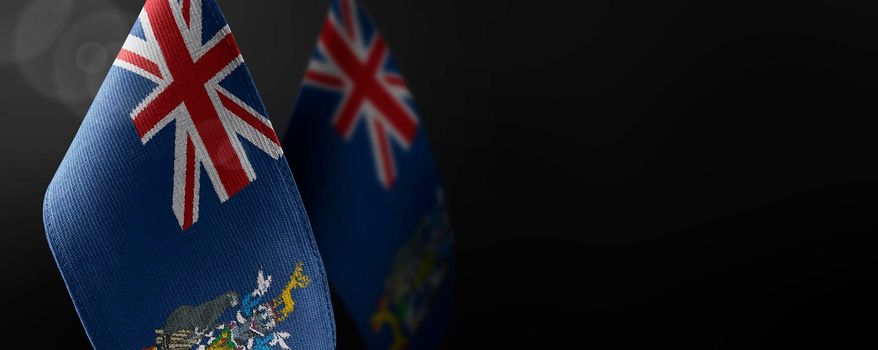 Small national flags of the South Georgia and the South Sandwich Islands on a dark background.