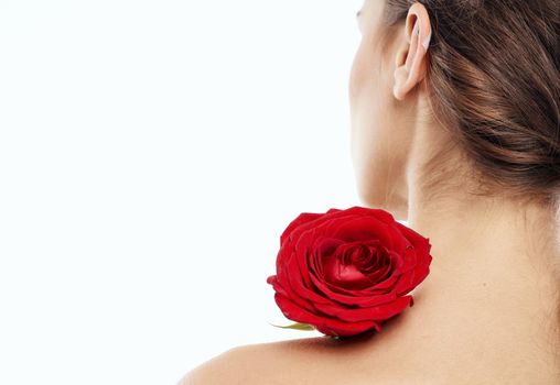 Romantic woman with red fragrant flower near the face clean skin cosmetology dermatology. High quality photo
