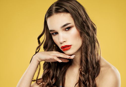 Brunette woman with red lips on a yellow background and makeup with eyeshadow. High quality photo