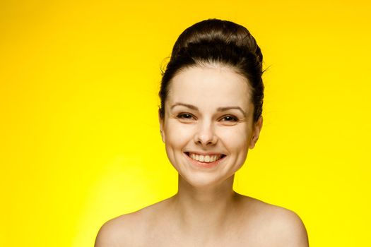 emotional woman with bare shoulders wearing fashion glasses gathered hair yellow background. High quality photo