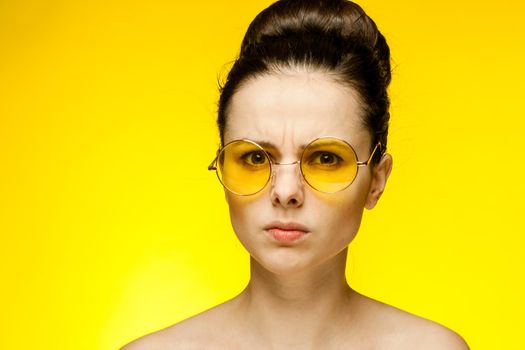 attractive woman with bare shoulders yellow glasses isolated background. High quality photo