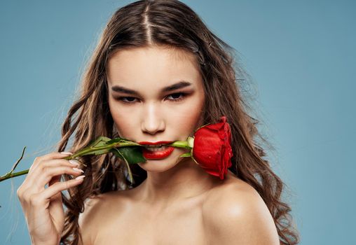 Red rose sexy woman naked shoulders makeup blue background. High quality photo