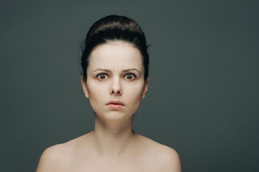 brunette with bare shoulders surprised look emotions clear skin. High quality photo