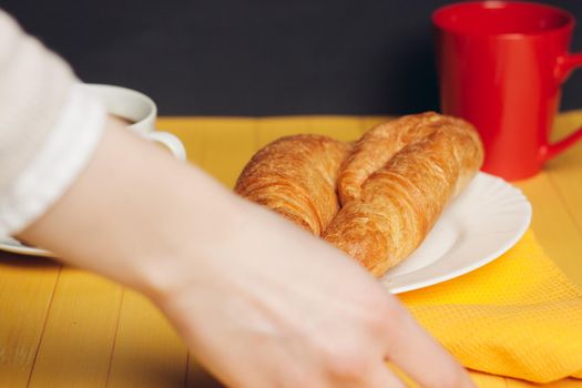 croissants plates wooden table drink mug breakfast dessert. High quality photo