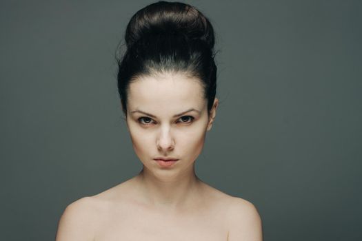 beautiful woman with bare shoulders clear skin collected hair emotions. High quality photo