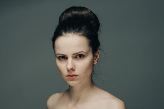 beautiful brunette with bare shoulders on gray background cropped view. High quality photo