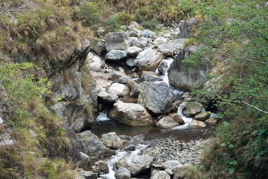 Wild river flow in forest with rock stones landscape in Taiwan.