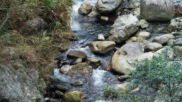 Wild river flow in forest with rock stones landscape in Taiwan.