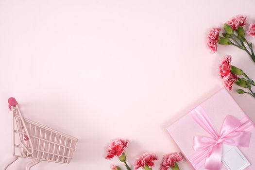 Concept of Mother's day holiday greeting design with carnation bouquet and gift on pink background