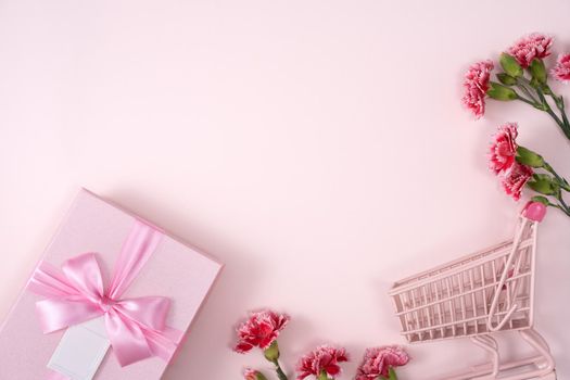 Concept of Mother's day holiday greeting design with carnation bouquet and gift on pink background