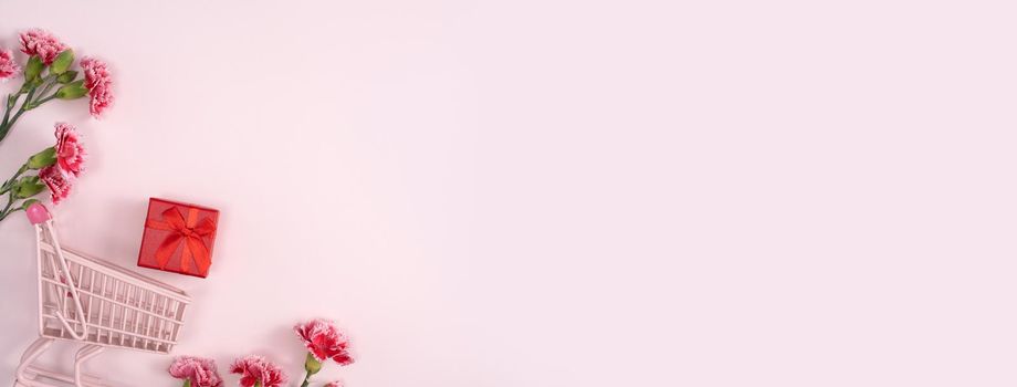 Concept of Mother's day holiday greeting design with carnation bouquet and gift on pink background