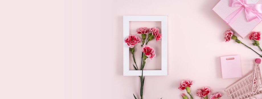 Concept of Mother's day holiday greeting design with carnation bouquet and gift on pink background