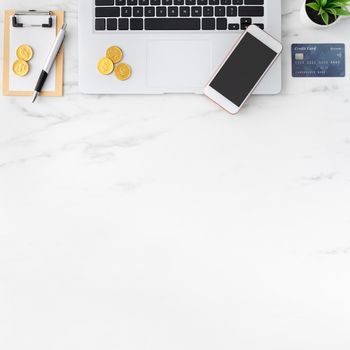 Top view of financial plan concept with credit card, laptop, note on white office table background.