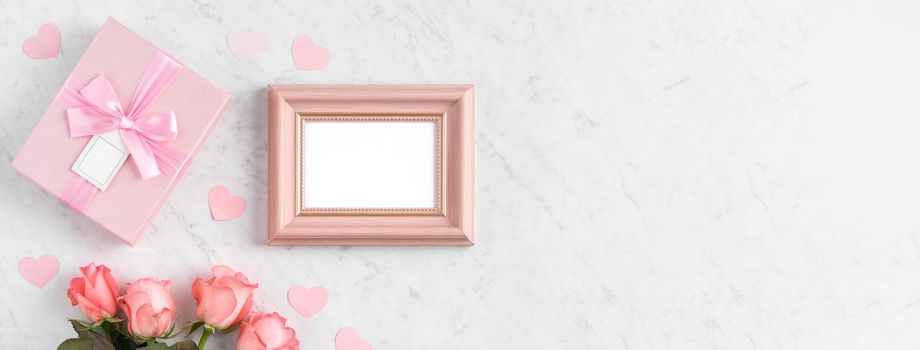 Giftbox and pink rose flower on marble white table background for Mother's Day holiday greeting design concept.