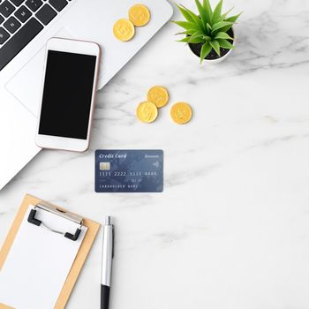 Top view of financial plan concept with credit card, laptop, note on white office table background.