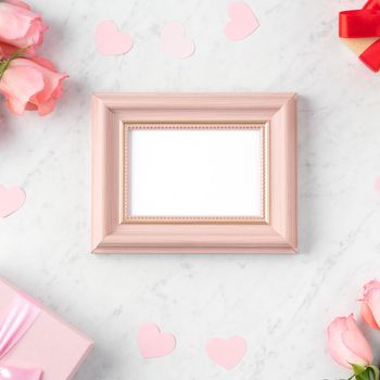 Giftbox and pink rose flower on marble white table background for Mother's Day holiday greeting design concept.