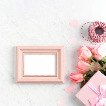 Giftbox and pink rose flower on marble white table background for Mother's Day holiday greeting design concept.