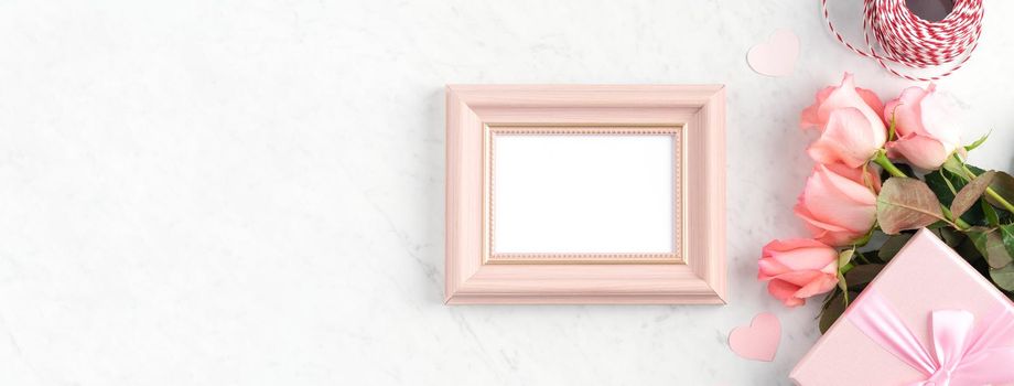 Giftbox and pink rose flower on marble white table background for Mother's Day holiday greeting design concept.