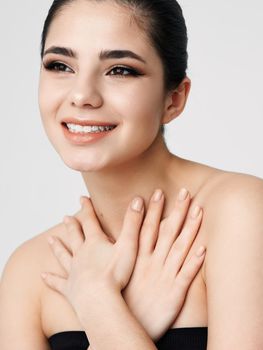 smiling woman face with makeup nude shoulders hands near neck. High quality photo