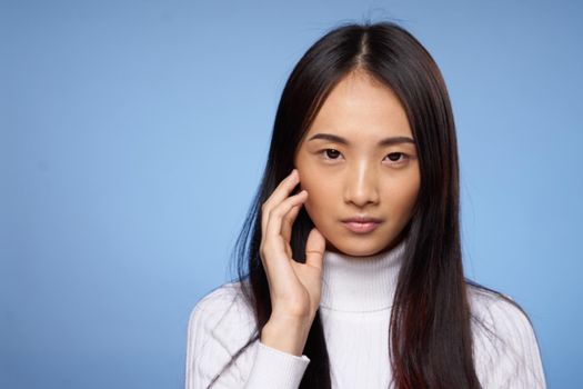 pretty woman with dark hair in white sweater gestures with her hands clean skin cosmetology. High quality photo