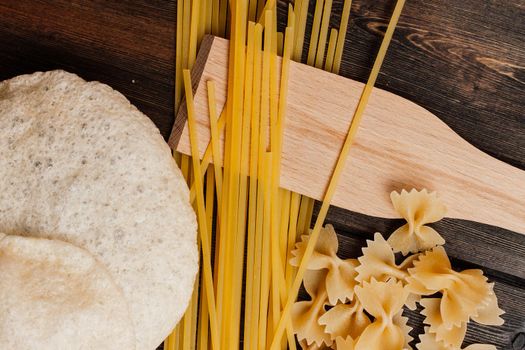 pasta on the kitchen table cherry tomatoes ingredients cooking italian. High quality photo