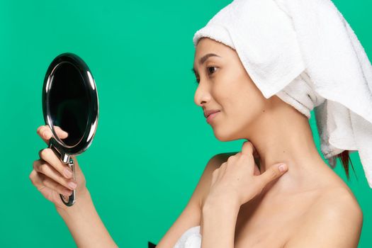 woman asian appearance grandfather pipe sweat face clean skin mirror in hands close up. High quality photo
