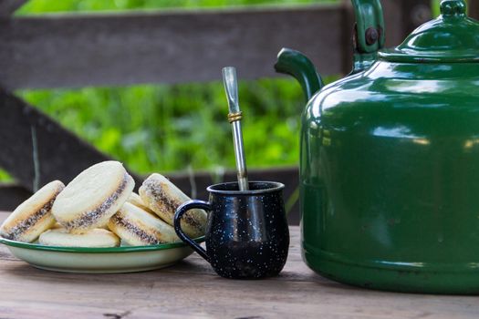 Mate and kettle with a plate of alfajores and yerba mate infusion in the Argentine countryside