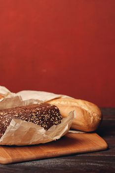 loaf of bread on a board baking flour product and red background. High quality photo