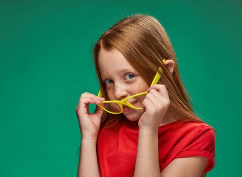 cute red-haired girl yellow glasses facial emotions school. High quality photo