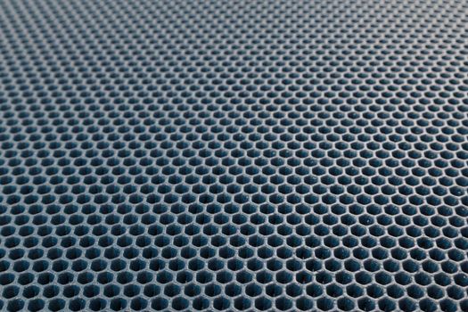 blue hexagonal punched EVA - ethylene vinyl acetate foam carpet linear perspective background with selective focus.