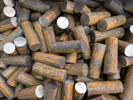 a pile of raw steel short bars cutted by saw- workpieces prepaired for forging, close-up with selective focus and background blur