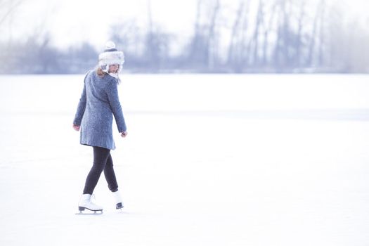 ice skating on the ice of a frozen lake young attractive woman.
