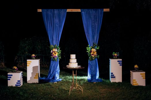 wedding decor with cake on a wooden bench against a waterfall background