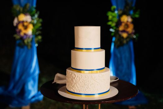 wedding decor with cake on a wooden bench against a waterfall background