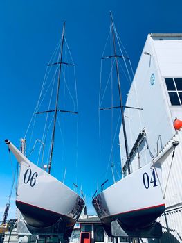 Russia, St.Petersburg, 26 May 2020: Port Hercules, the sailboats stand on supports, the bottom view, masts and the slings, a clear sunny weather, the blue sky, the bottom of the boat and kiel, logo