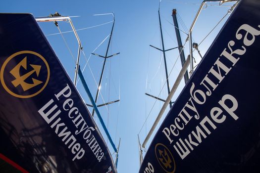 Russia, St.Petersburg, 26 May 2020: Port Hercules, the sailboats stand on supports, the bottom view, masts and the slings, a clear sunny weather, the blue sky, the bottom of the boat and kiel, logo