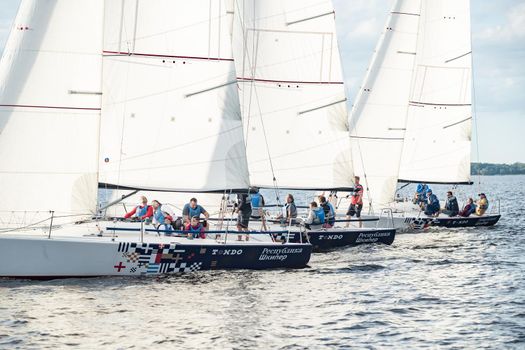 Russia, St.Petersburg, 06 July 2020: The Sail boats regatta at Neva river at sunny day, start of race, fun, passion, Sun patches of light on water. High quality photo