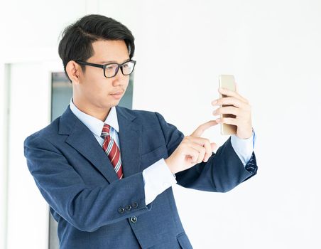 Young asian business men portrait in suit  holding smartphone against white background