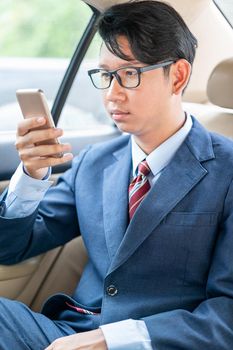 Young asian business men portrait in suit  talking on the phone in car