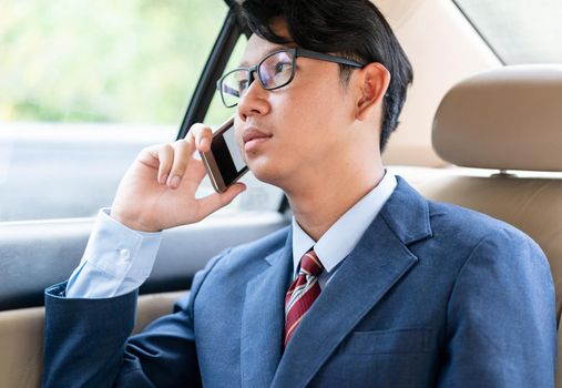 Young asian business men portrait in suit  talking on the phone in car