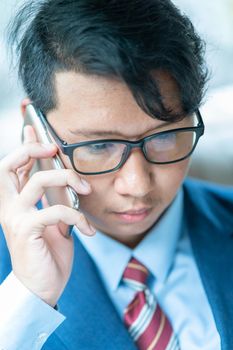 Young asian business men portrait in suit  talking on the phone in car